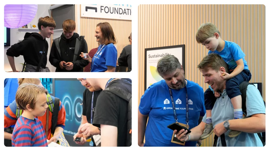 Young visitors at the booth: teenagers chatting with a volunteer, a child exploring a demo, and a boy on his dad’s shoulders looking at a phone with a volunteer.
