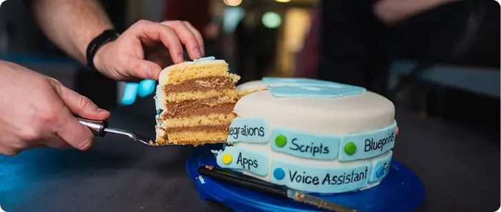 Cutting a slice of cake themed with the Home Assistant logo